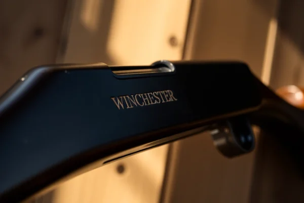 An authentic 32WIN rifle showcasing detailed craftsmanship, positioned on wood with warm lighting for vintage rifle enthusiasts.